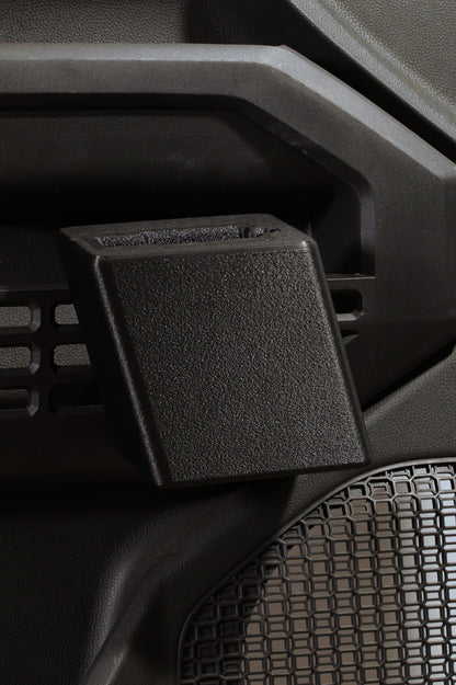 A close-up of a black textured plastic handgun holster attached to a dark gray vehicle door panel for a Toyota.
